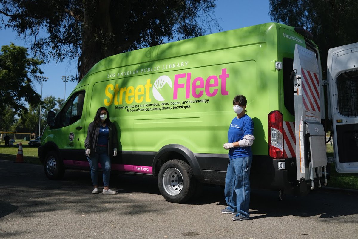 two library staffers standing in front of street fleet van