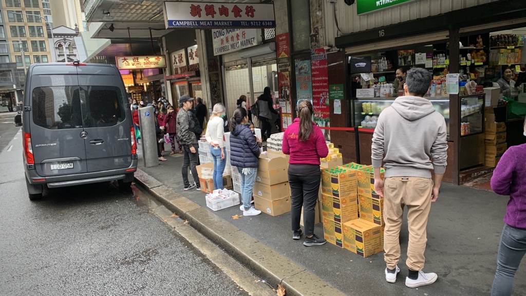 Thaitown, Sydney, 1pm. They’ve started handing out today’s food and essentials to students etc. The last item is an envelope with some cash. The people you see lined up here are maybe a quarter of the queue, which stretches back around the block.