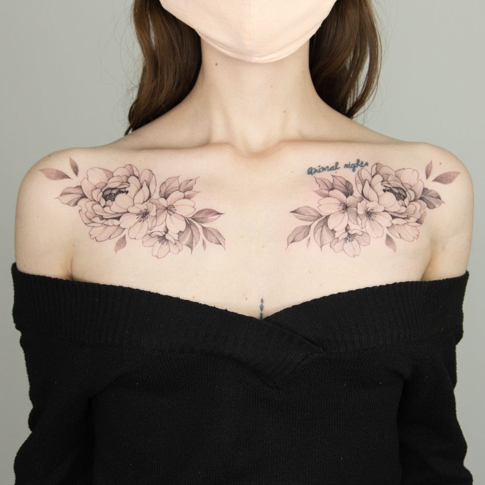 Tiny flower tattoo on the collarbone.