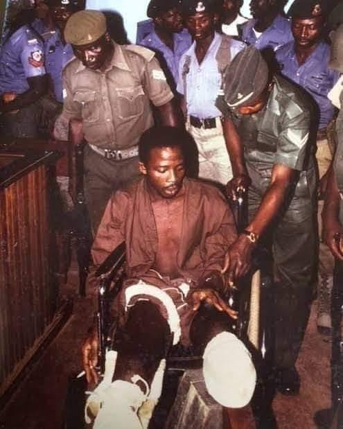 He confessed that he was Anini, rolling on the floor in pain, he was whisked away.He was transferred to the military hospital, heavily guarded for treatment, his bullet ridden leg was eventually amputated.He was then confined to a wheelchair for his interrogation and trial.