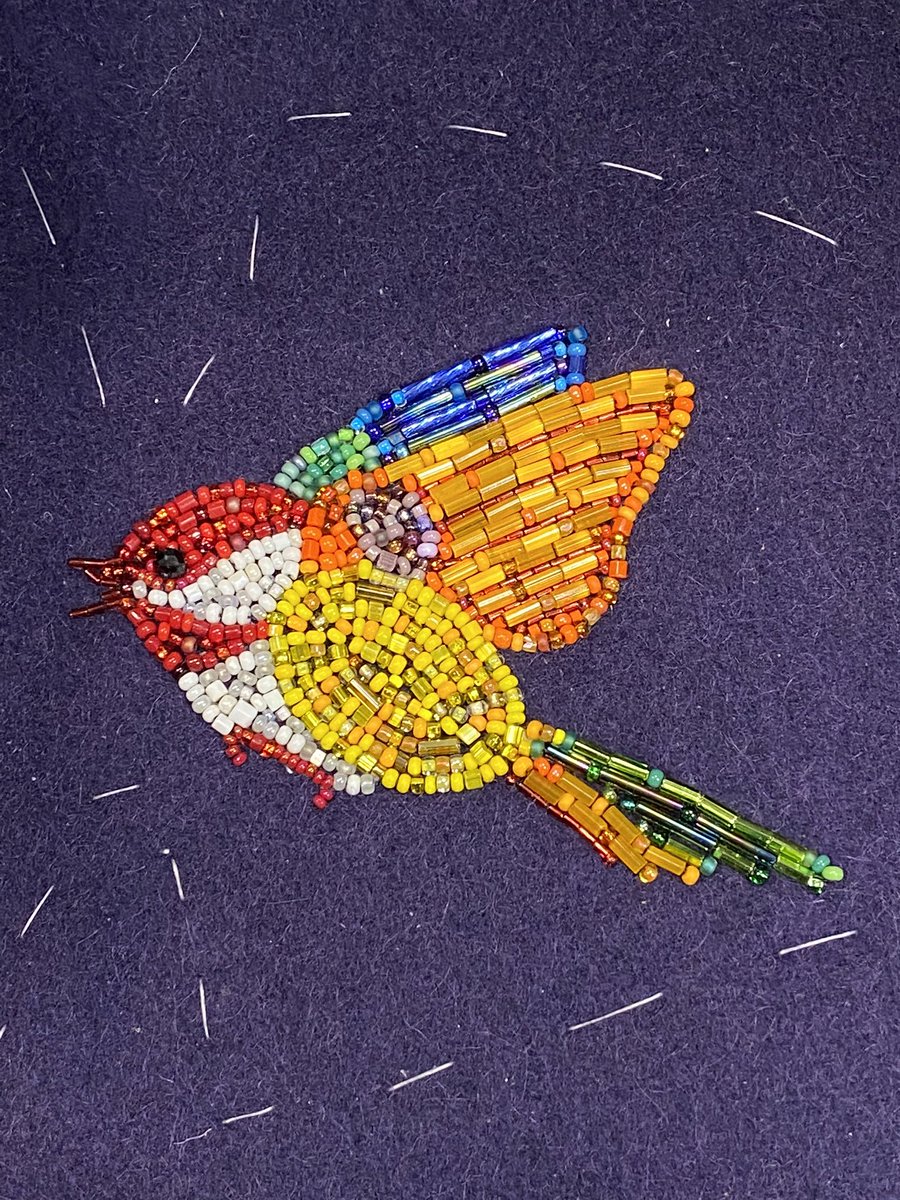 I just wanted to show the texture of the wings & tail here. The white threads are from the baste stitch being used to hold the wool fabric & interfacing in place while I bead the piece.  #beading  #métis