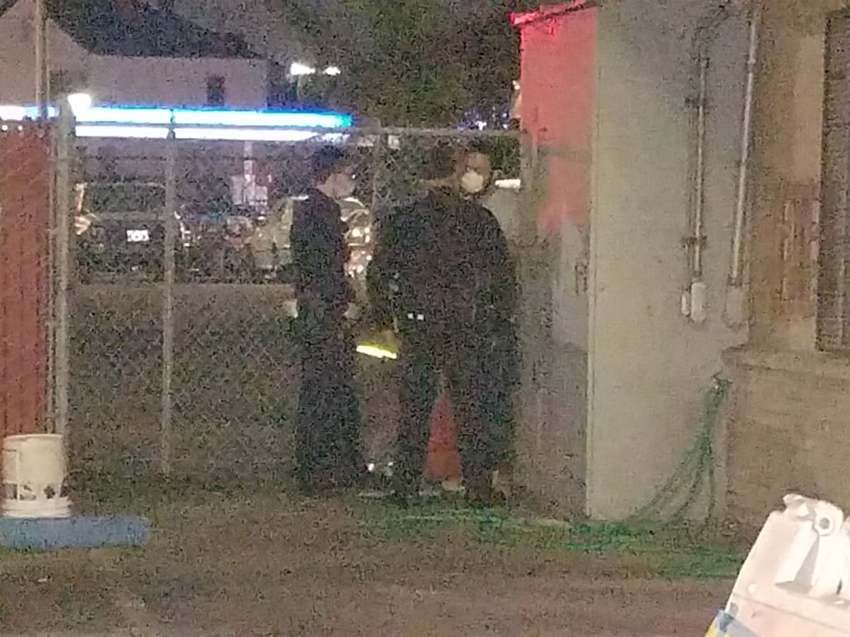 Lead cop and presumably higher ranking cop who just pulled up are speaking with manager in dark corner outside of motel. Unclear what the plan is, why fire department hasn't been called to cut her free.