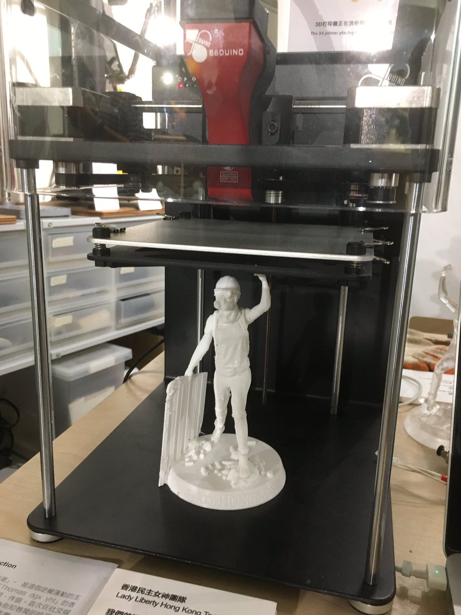 A portion of the exhibit shows how  #LadyLiberty was made, prototypes manufactured with a 3D printer that plays  #GloryToHongKong over and over again.