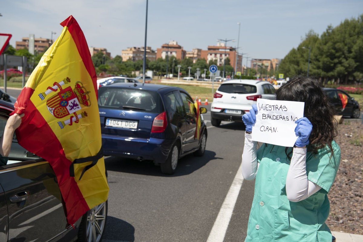 Una sanitaria sale con un cartel de "La banderas no curan" en Ciudad Real como respuesta a la manifestación producida hoy. ¿#LaEspañaSolidaria o #LaEspañaDesfasada?