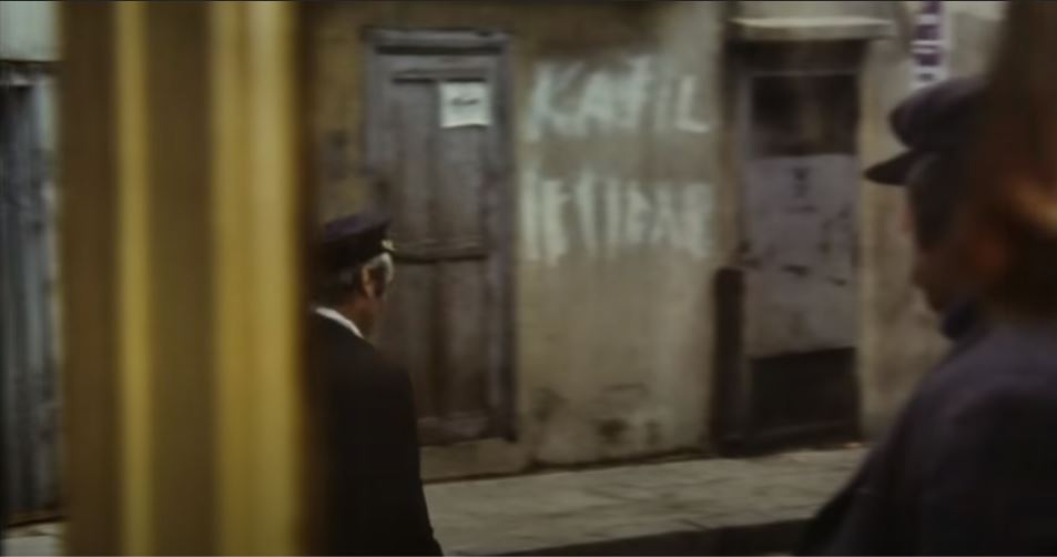 Filmdeki muktedir Zabıta Şakir'in arkasında buğulu bir "Katil iktidar" yazısı