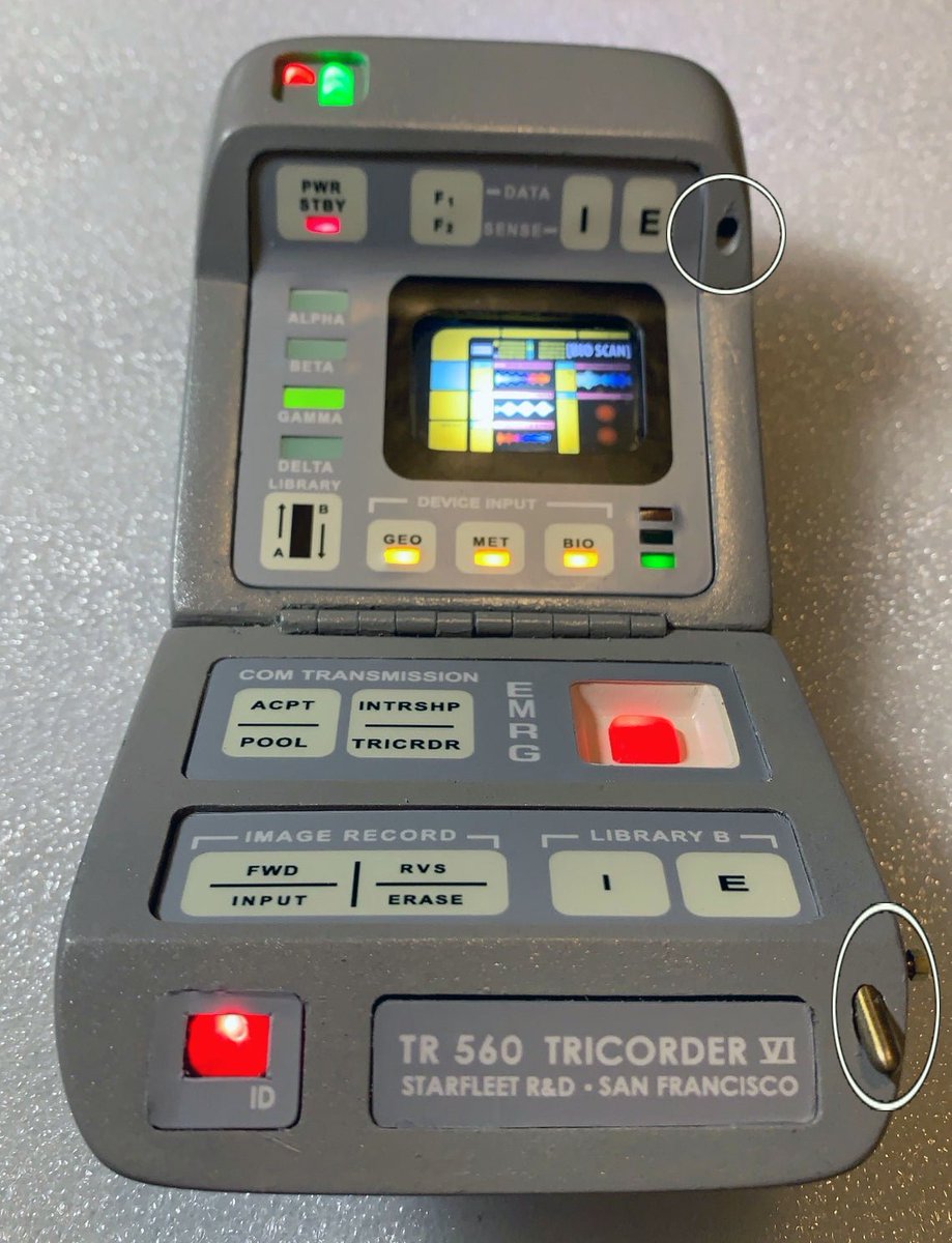 In this fan-built replica, the 'switch' is pulled towards the user while the door is the 'open' position, exposing a metal tab.When the original prop was in the 'closed' position, the metal tab fit into the slot in the upper portion of the tricorder to keep the door shut.