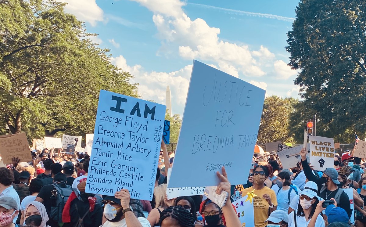 Photo from the DC protest showing various protest signs demanding justice for Black lives lost to police brutality.