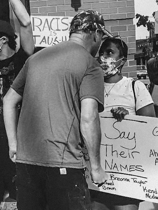 In Whitefish, Montana, a young woman named Samantha Francine is confronted by a large white man with balled fists, shouting, "Black Lives Matter? Fuck you! Fuck you! Fuck you!" She does not look away. This is America, 2020. (Photo by Grace Jensen)  https://www.facebook.com/photo.php?fbid=10223827665665524&set=a.1070301483715&type=3&theater