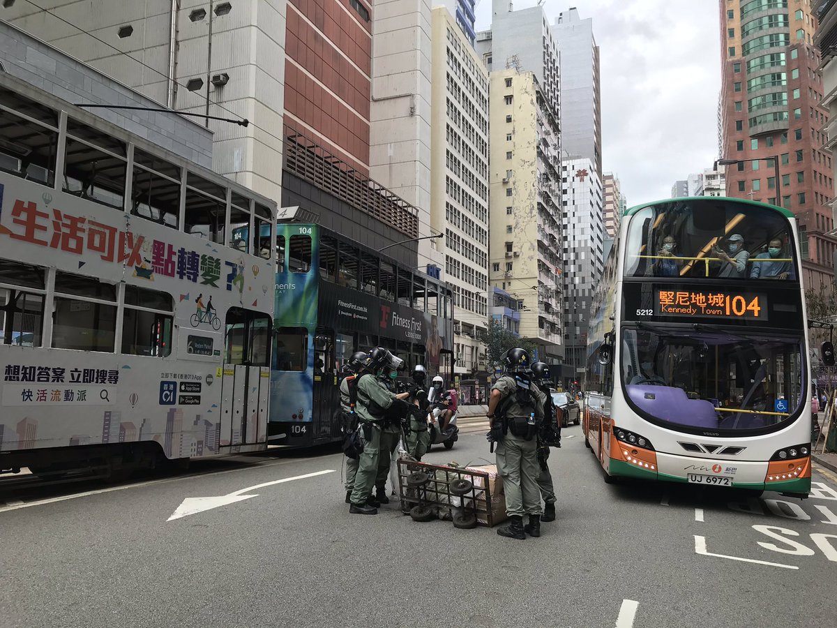 It now takes a team of six armed riot police officers to clear away one stray push cart in Hong Kong.