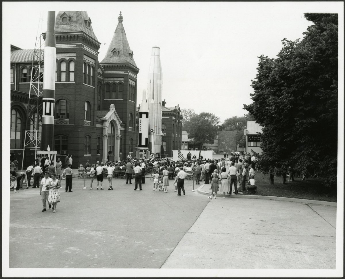 People walk in the street outside of the Arts and Industries Building. 
