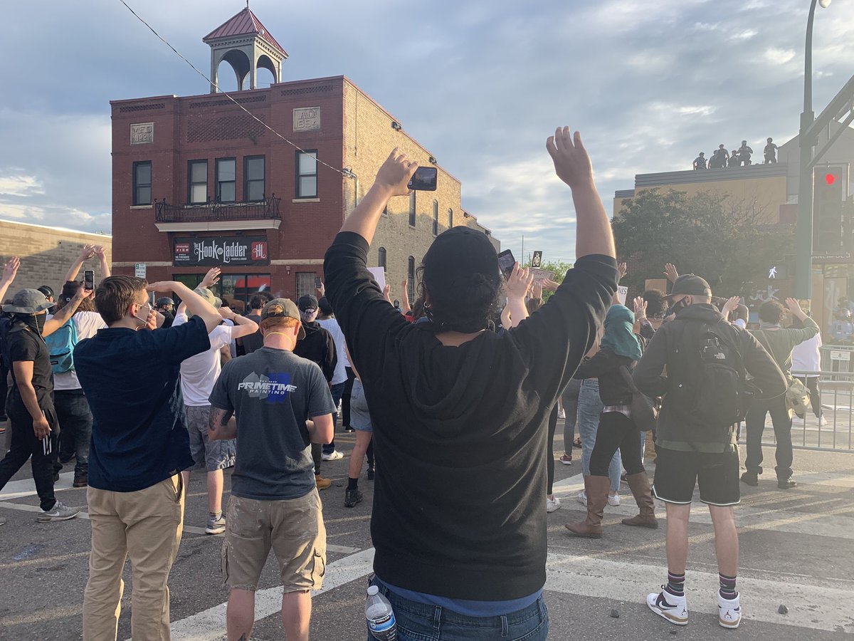 Many more police and many more protesters than earlier outside of the 3rd precinct near Lake St. and Minnehaha Ave. People put their hands up after someone threw a rock at police and an officer aimed his orange projectile launcher toward the crowd.