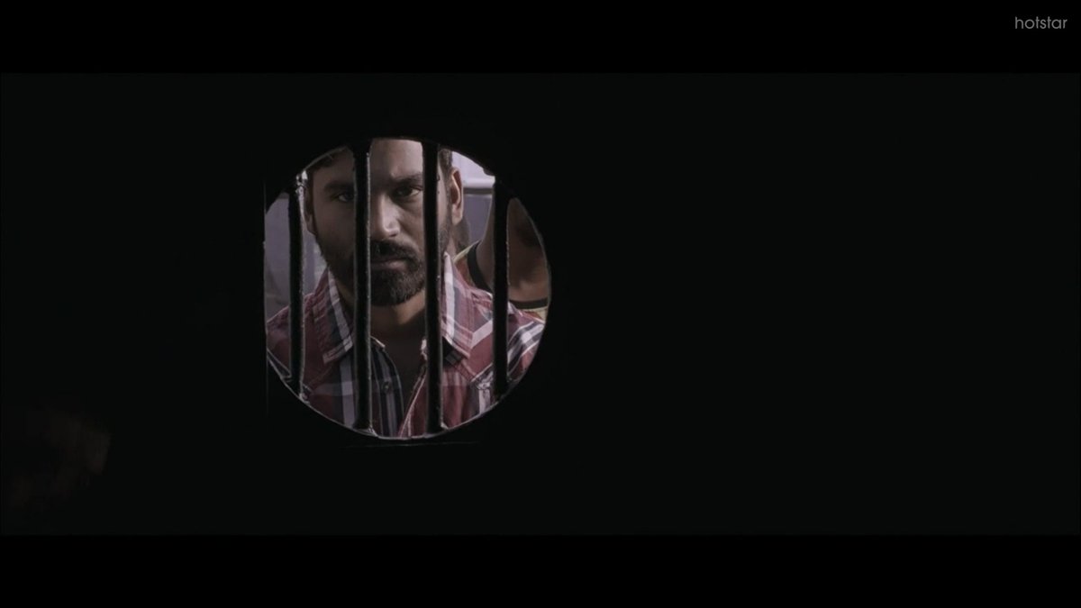 Anbu is introduced as an enigmatic person, he seems extremely pale and harmless. Without much delays, Vetrimaaran builds a huge intrigue factor over his character for he being sent into the cabin of ghosts. Again, The jail environment, the hierarchy among the convicts is ironic.