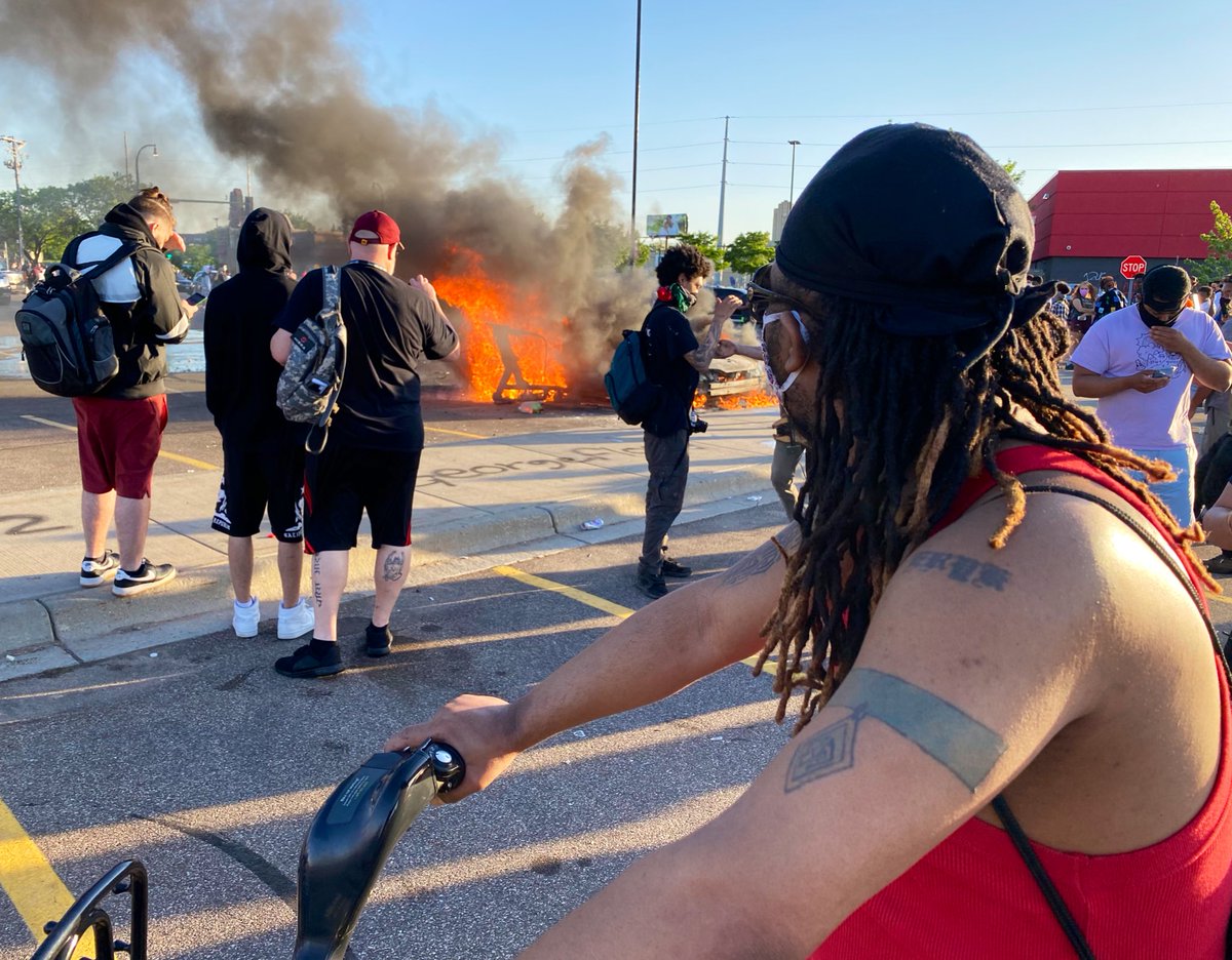 Night three in   #Minneapolis. 500+ people in a looted Target parking lot watching a torched car while a music group plays an acoustic set a few yards away.   #NBCNews – at  Target