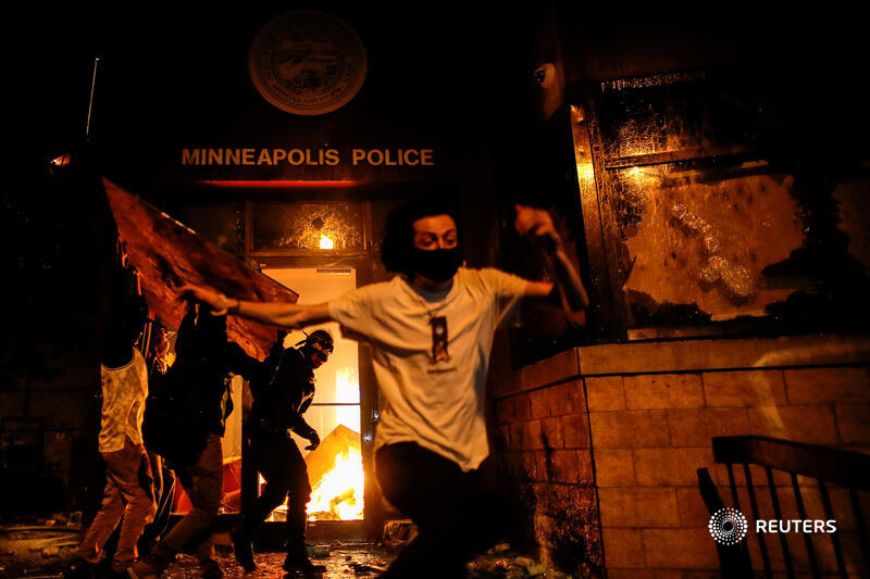 Protesters react as they set fire to the entrance of a police station. More photos from Minneapolis:  http://reut.rs/2ZOkORM    @ReutersBarria