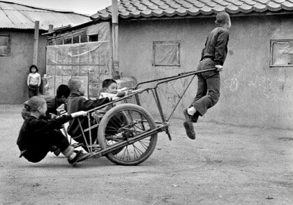 나도 어릴적 리어카로 저렇게 놀며 까불다가 리어카 손잡이를 놓쳐서 철 파이프 손잡이가 내 코를 치는 바람에 병원으로 직행하는 난리가 났었다.
지금도 코뼈가 살짝 내려앉은 흉터가 남아 있는데, 그때 난생처음 밝은 대낮에 별을 보았다. 

(사진 : 김기찬 1970년대)