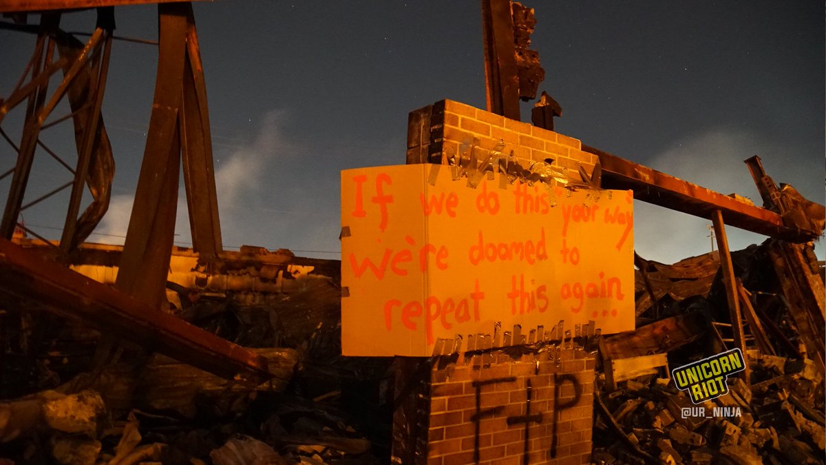 Slide 17: a protest sign has been affixed to a tower of bricks still standing amidst the burned rubble of the AutoZone:"If we do this 'your way' we're doomed to repeat this again..."Behind the remains of the building, stars are visible in the night sky.  #JusticeForGeorgeFloyd