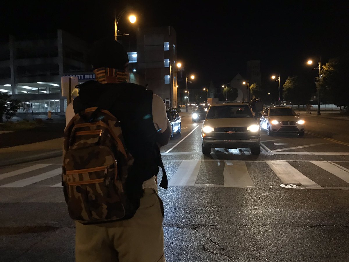 A man stands facing traffic at MLK Blvd and BB King. Some cars honked in support.