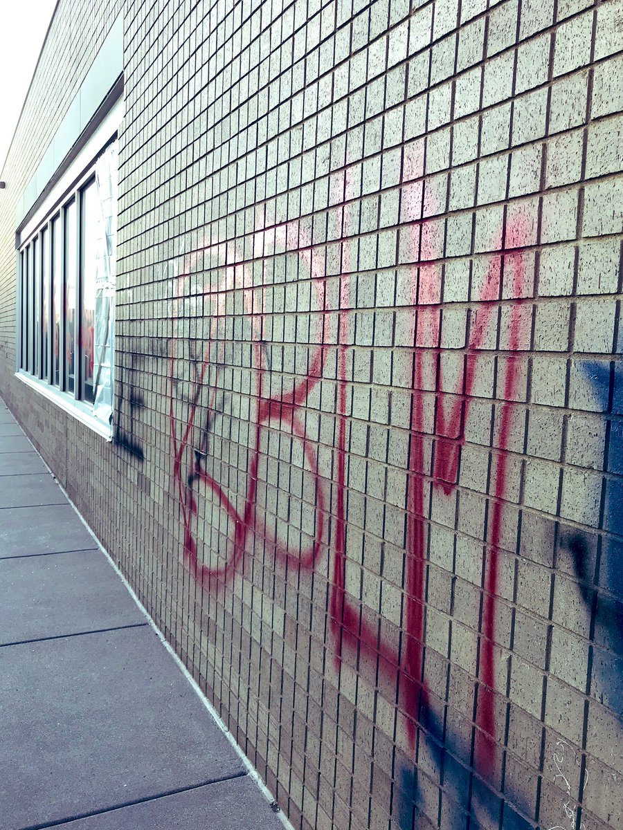 The library is somewhat damaged, smashed computers inside too, but all the books appear untouched. Graffiti suggests killing cops.