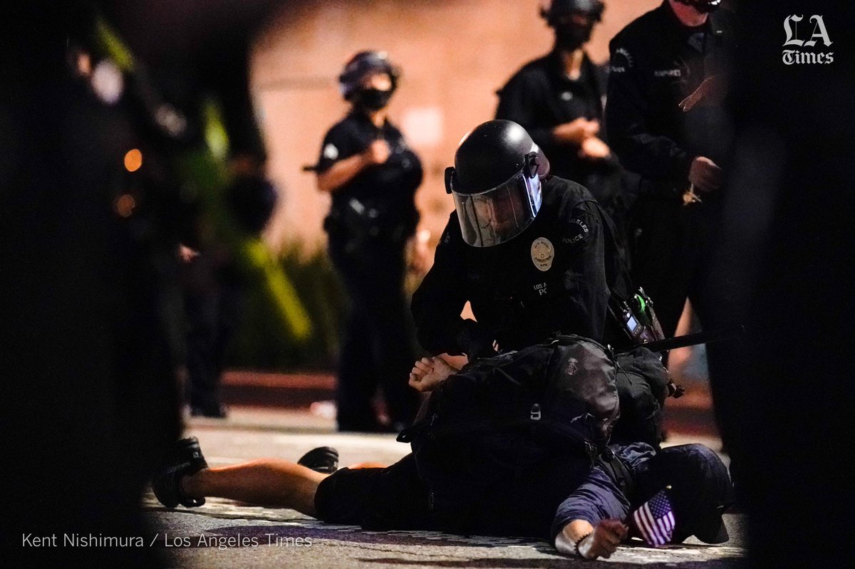 kentnish's tweet image. A protestor holding a tiny US flag was brought to the ground by law enforcement. #dtla