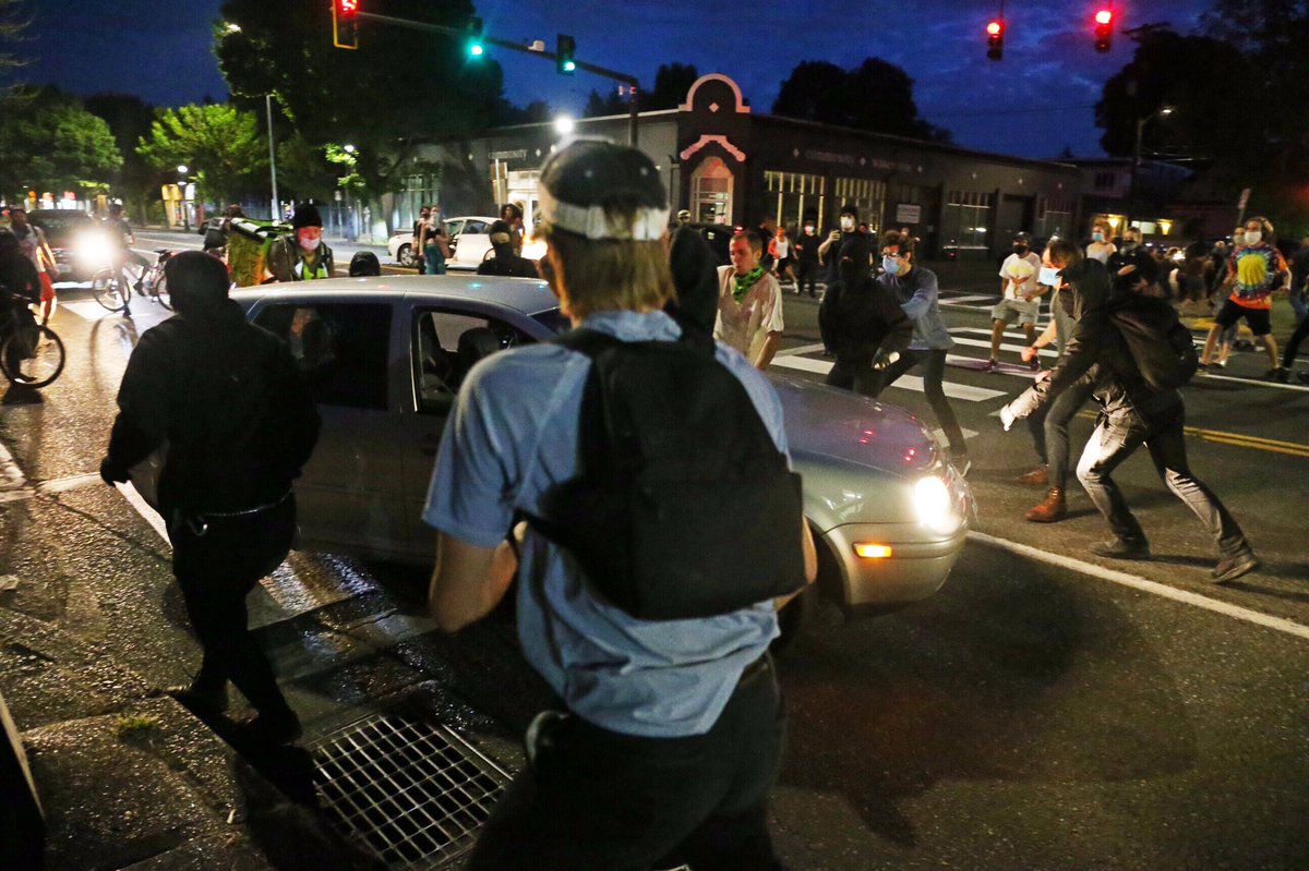 At the corner of NE Shaver & MLK, a VW Gold lunged into the crowd. It was pummeled & pursued in reverse down shaver and stopped. After an altercation I couldn’t see, roared south. I heard two loud pops, people ran, then it raced back north through intersection & hit skateboarder