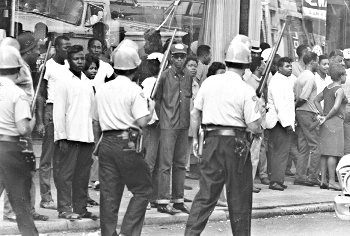 Dayton, Ohio, 1966Lester Mitchell, a thirty-nine-year-old Black man, was shot in the face while sweeping his front porch. Witnesses saw white men in the car that did the drive-by. After years of discrimination, the death of Mitchell sparked rioting and looting across the city.