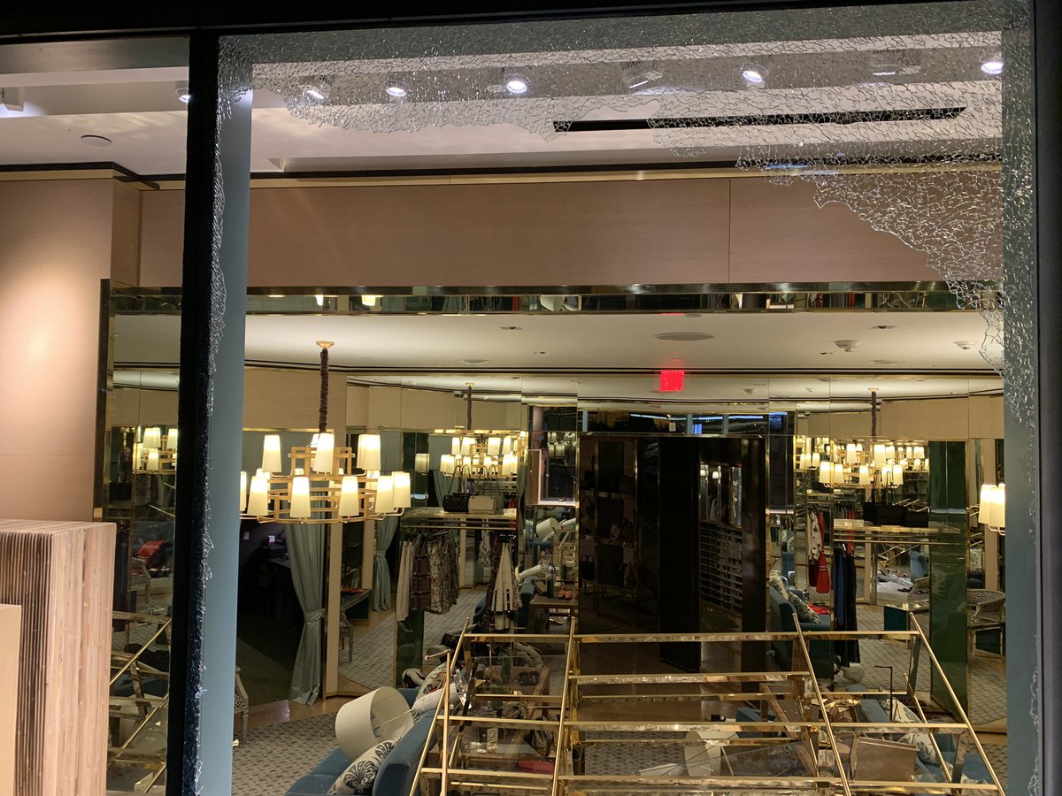 A person grabs a few backpacks from a seemingly fancy mall store