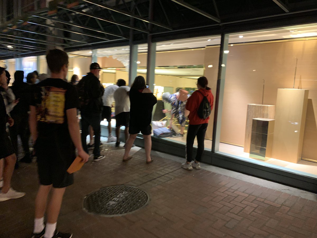 A person grabs a few backpacks from a seemingly fancy mall store