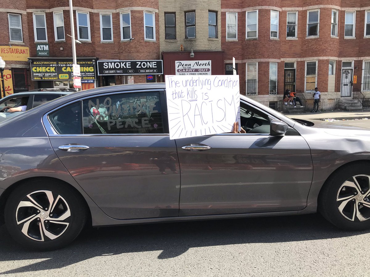 Another car in the car parade protest. Helicopters overhead, police mobile command is outside the library.