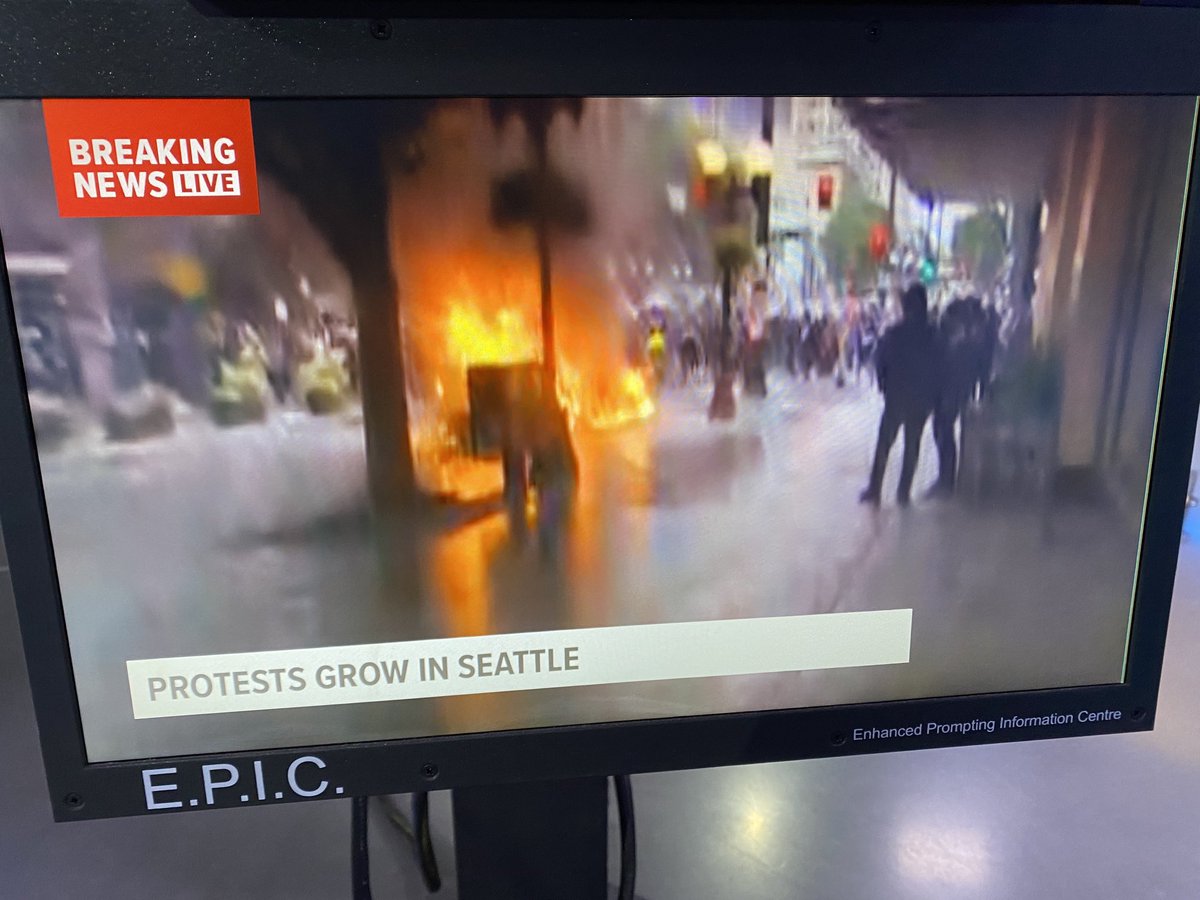 MarkWrightSEA's tweet photo. BREAKING: Riot in DT Seattle is turning violent. Police cruiser    destroyed by fire at 5th and Pine. SB I-5 shut down now by protestors. Live on the air now. https://t.co/cp8MLa8Vhb
