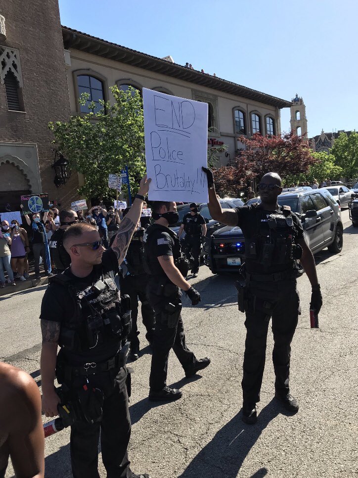 Davis_Hammet's tweet photo. “The @kcpolice held a protest sign against police brutality!” 
Then used those giant pepper spray bottles they’re holding on protesters. 

“The @kcpolice took a knee in solidarity!” 
They kneeled down to put on gas masks before gassing peaceful protesters including children. https://t.co/B4jWfPyUlT