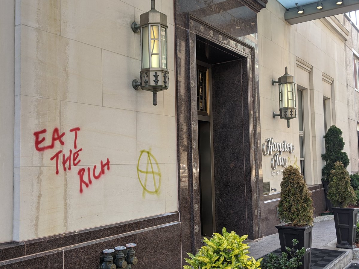 "Eat the rich" is spray-painted on a Hampton Inn.