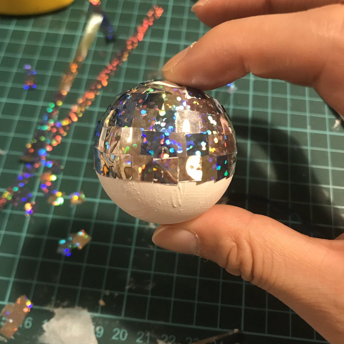 えむたろう 今回の写真のためにミラーボール自作しました 作り方は簡単 ピンポン球にホログラムの紙を切ってボンドで貼っていくだけです 隙間からピンポン球のオレンジ色が見えないように白のアクリル絵具で下地を作りました 材料は全部百均です