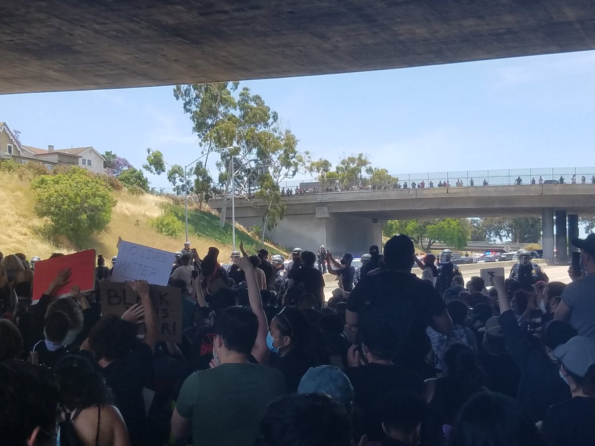 The police have stopped the protest from moving south right before the Imperial Ave exit. They are kneeling under a bridge.