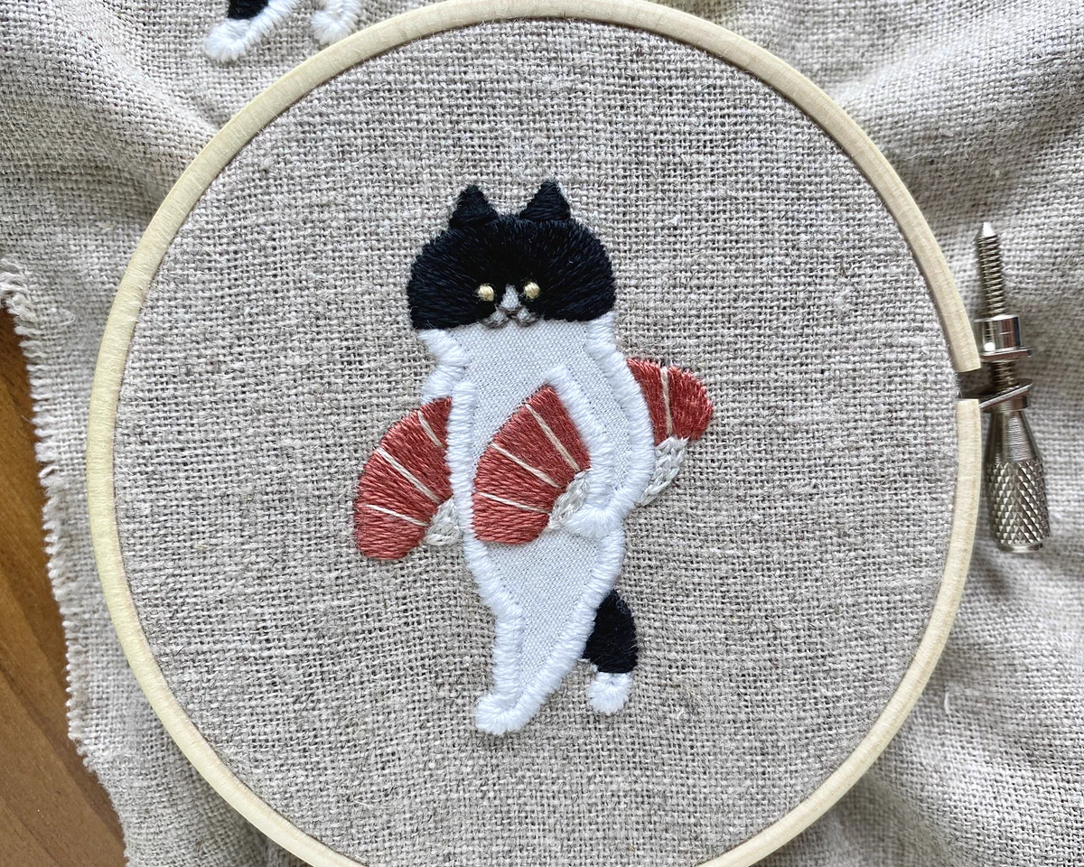 お寿司をたくさん食べたい猫の刺繍！両脇にお寿司を抱えてる姿が可愛すぎる！