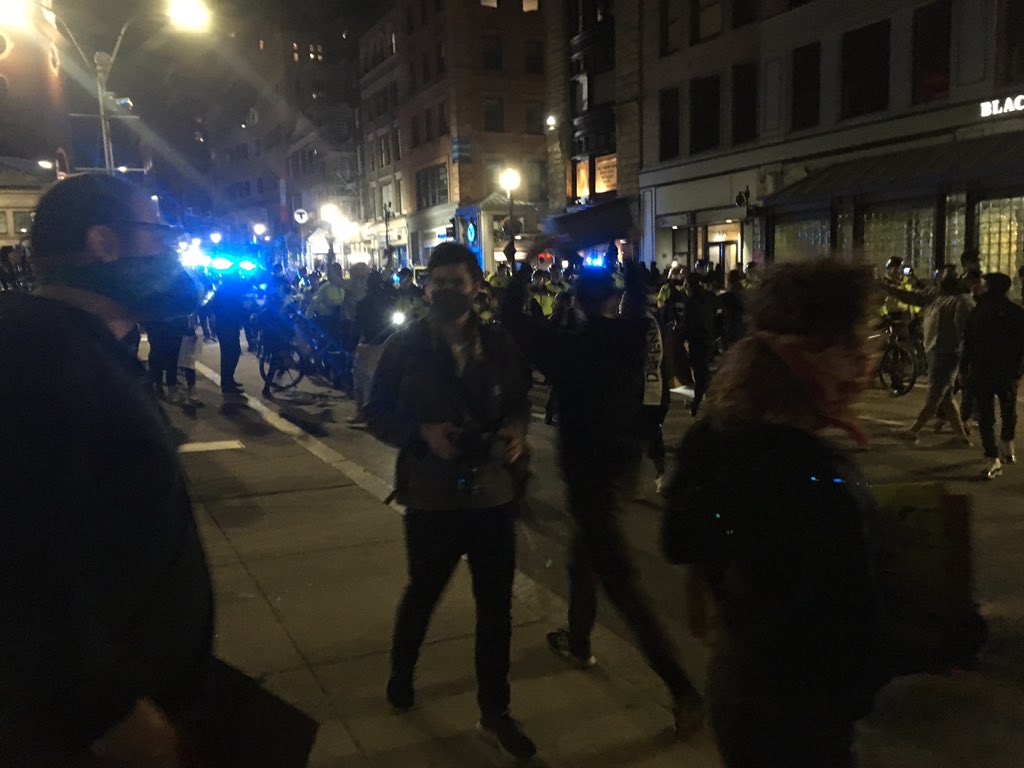 Bike unit slowly marching down Tremont; many water bottles being thrown as a handful of protesters face down cops in the street.  #BostonProtest