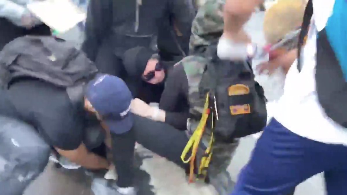 More muscle comes in from the left to take the rock hammer, and the team leader puts Antifa in a headlock.Look how CALM the team leader is.