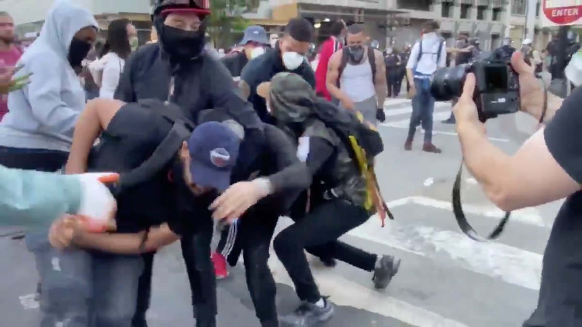 More muscle comes in from the left to take the rock hammer, and the team leader puts Antifa in a headlock.Look how CALM the team leader is.