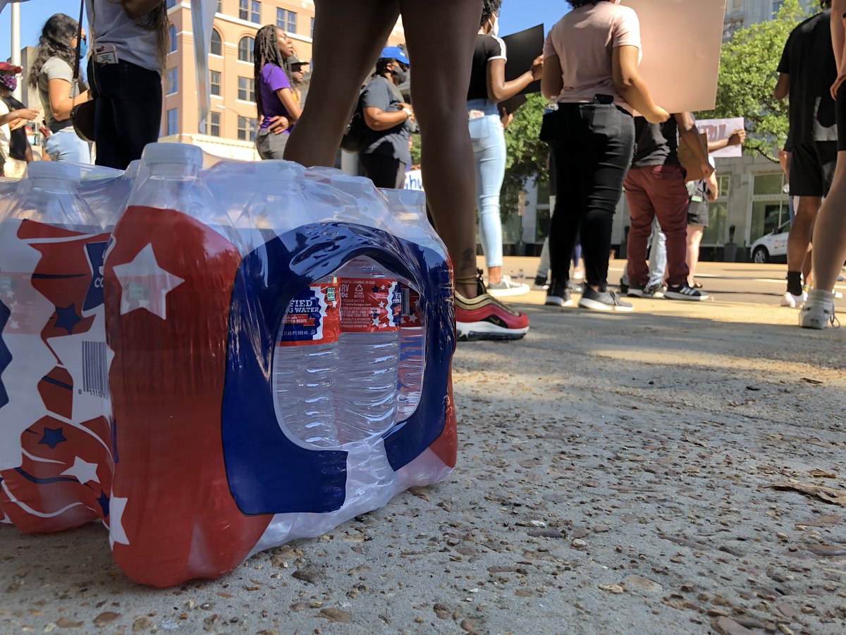 ChelseyOnTV's tweet photo. Signs and visuals from the protest, an hour later. Several cases of water have been brought by spectators supporting the cause. #NoJusticeNoPeace #ProtestMs https://t.co/ifjHJOiD8H