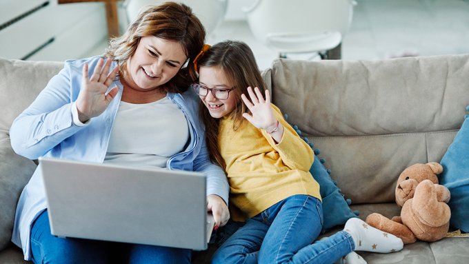 Imagen: Una madre y su hija mirando un ordenador juntas.