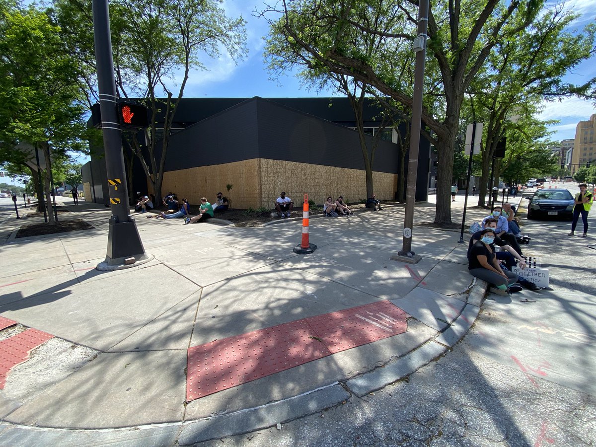 Small crowd of protesters moving into the shade a bit.