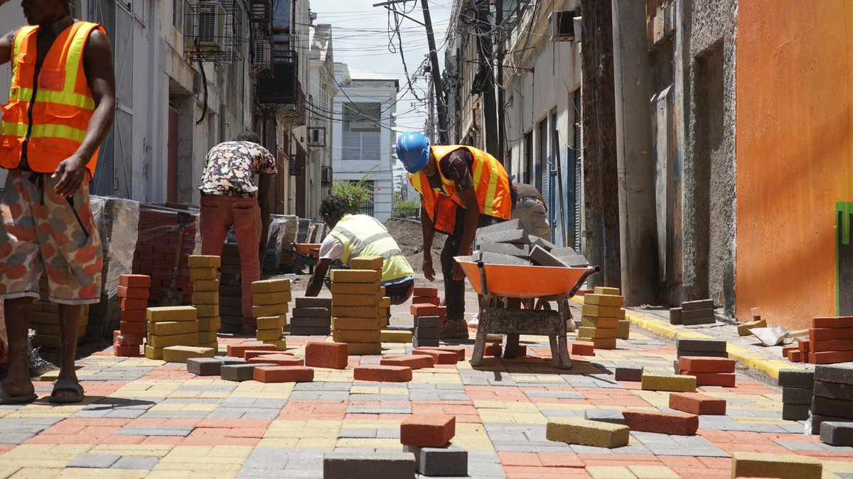 DWilliamsJam's tweet photo. Having completed the paving along sections of #WaterLane, @ksamcorp team moves ahead with paving sections of #TempleLane. This will run North to South and include sections with murals from both @kgncreative and Mexican Muralist Irving Cano and @alum_emc. #StillBelieving https://t.co/anbSd27tAC