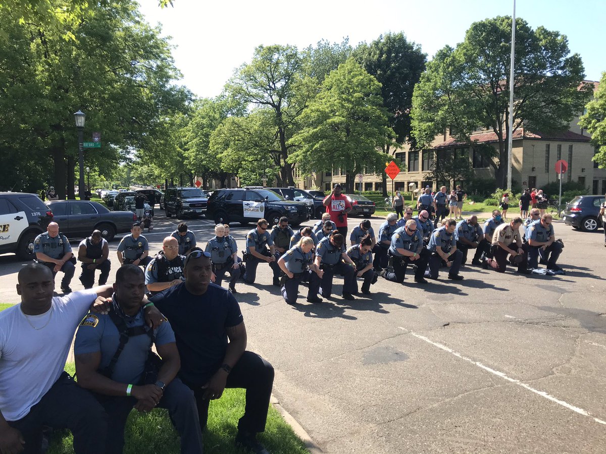 MN_CRIME's tweet photo. Officers take a knee during a large protest outside of Governor Walz's residence in St. Paul just moments ago. https://t.co/VKwUR5iW0b