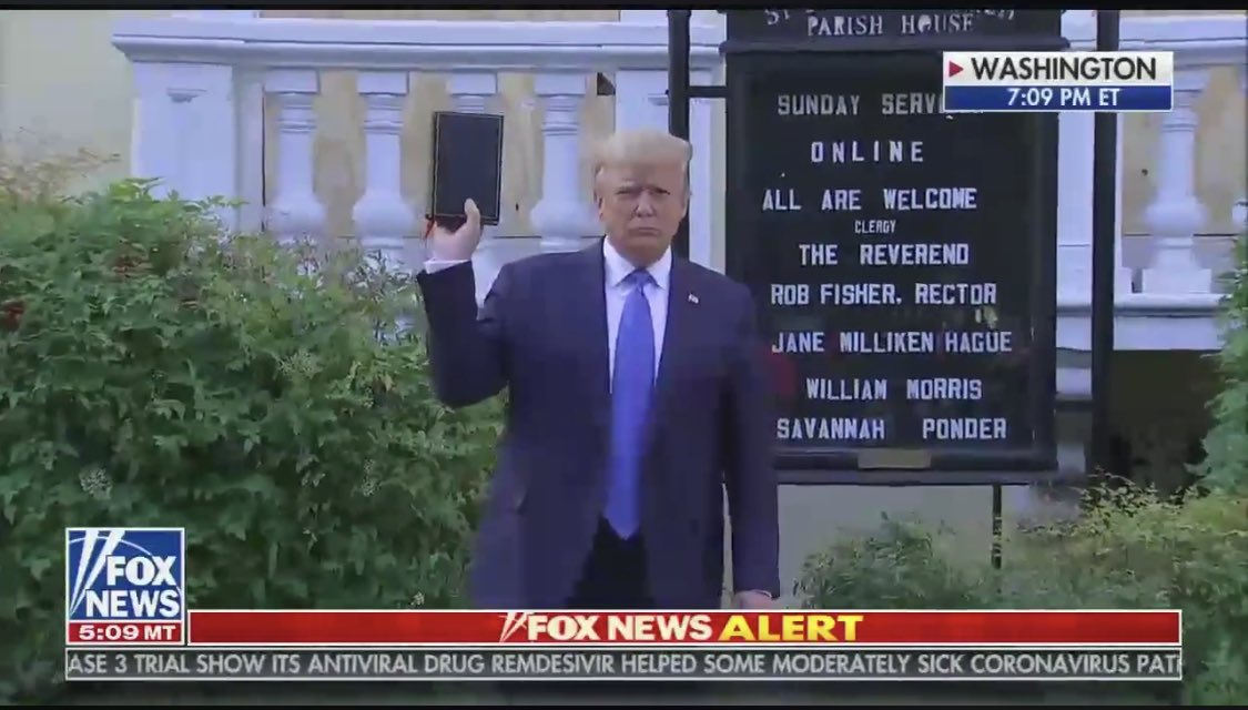 He’s standing in front of a church sign that says: 

ALL ARE WELCOME