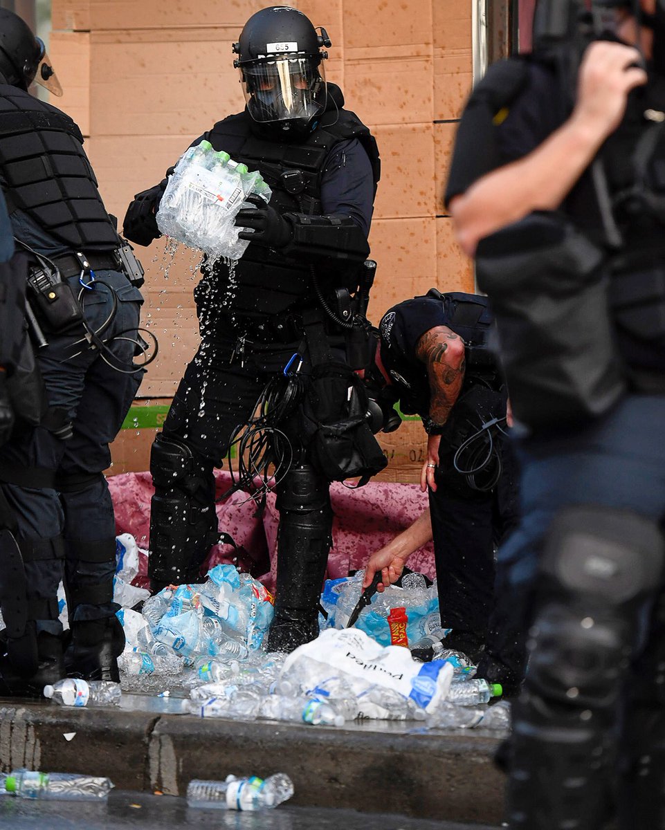 Asheville Police surround a medic station created by protesters as they stab water bottles with knives and tip over tables of medical supplies and food June 2, 2020. The medic team, made of EMTs and doctors, said the medical station was approved by the city. #avlnews