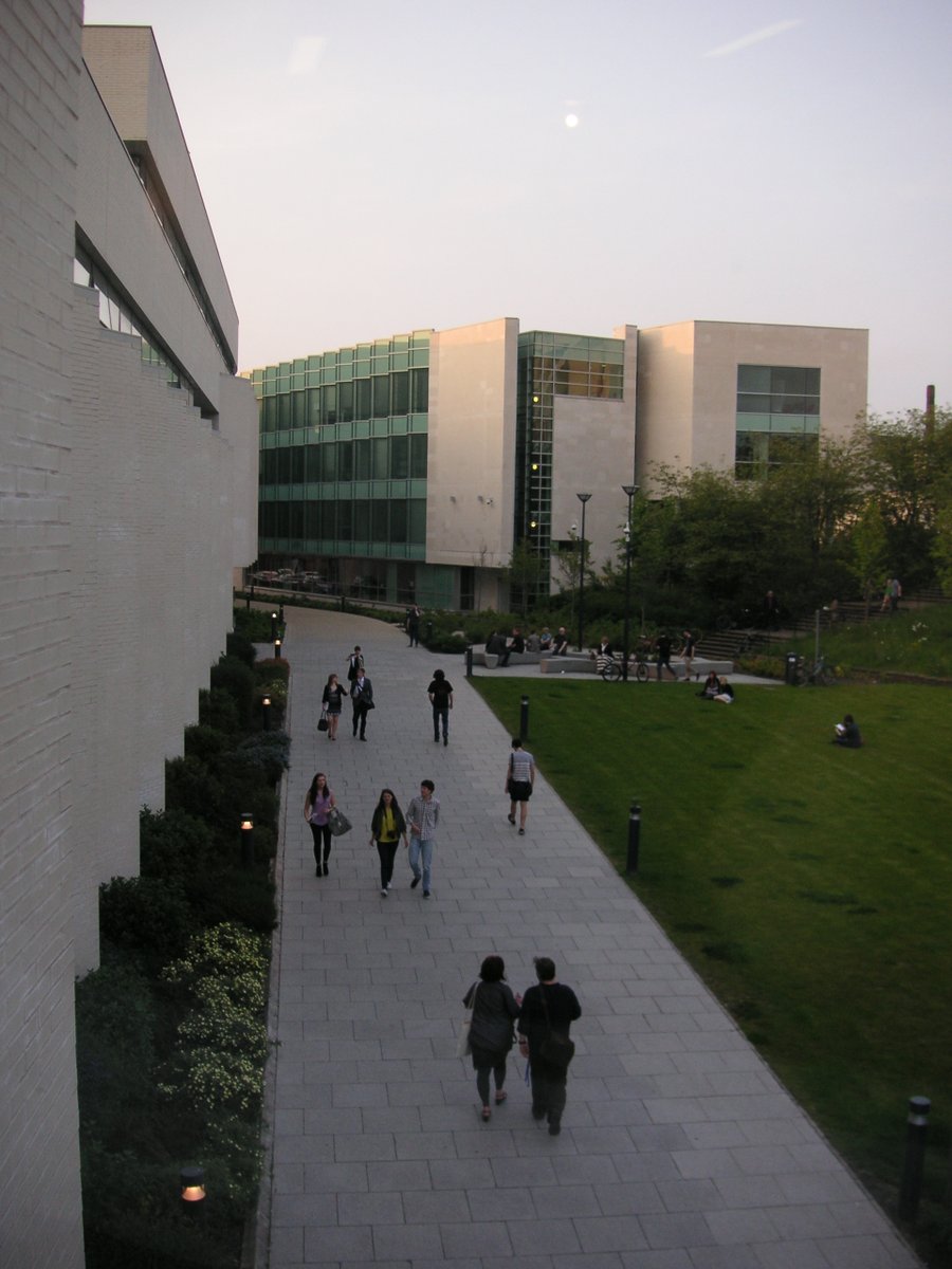 a group of people walking down a street next to a building

commons.wikimedia.org/w/index.php?cu…