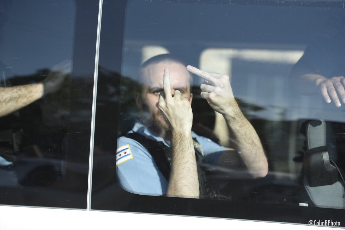 A van of about a dozen Chicago police officers turns south from Armitage onto Burling at the tail-end of the protest group, one police officer clearly flipping off the protesters from the van. (Last photo taken by  @yes_this_is_ben).  @Chicago_Police