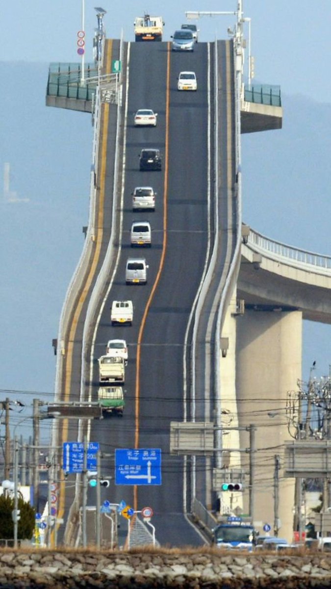 Rainmaker1973's tweet photo. Seeing pictures like this, travelers expect that the Eshima Ohashi Bridge in Japan to be 45° inclined, while it's just few degrees. Surprisingly, images like this aren’t necessarily photoshopped. What we’re seeing is perspective distortion https://t.co/94BKyfuhpy https://t.co/FX8fwMx45p