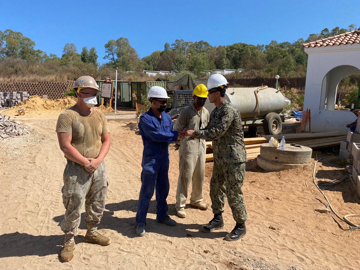 Senior Chief Constructionman Enrique Molina presents a challenge coin to workers assigned to Naval Mobile Construction Battalion 11, Eighth Engineer Support Battalion, and Tunisian Engineers in Tabarka, Tunisia, Aug. 18, 2021. U.S. Sixth Fleet, headquartered in Naples, Italy, conducts full spectrum joint and naval operations, often in concert with allied and interagency partners in order to advance U.S. national interests and security and stability in Europe and Africa.