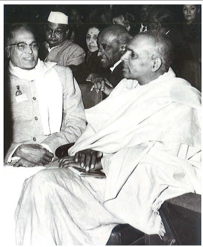 Swami Ranganathananda seated with Jayaprakash Narayan at a 50th death anniversary event of Leo Tolstoy, 1960.
