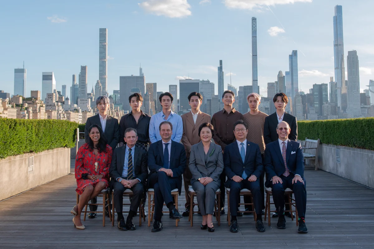 BTS with New York City’s Commissioner for International Affairs, Penny Abeywardena; Met President and CEO, Dan Weiss; Marina Kellen French Director of The Met, Max Hollein; First Lady of the Republic of Korea, Kim Jung-sook; Minister of Culture, Sports, and Tourism for the Republic of Korea, Hwang Hee; and Douglas Dillon Chairman of the Asian Art Department, Mike Hearn. The group is photographed on The Met's Cantor Roof with the New York City skyline in the background.